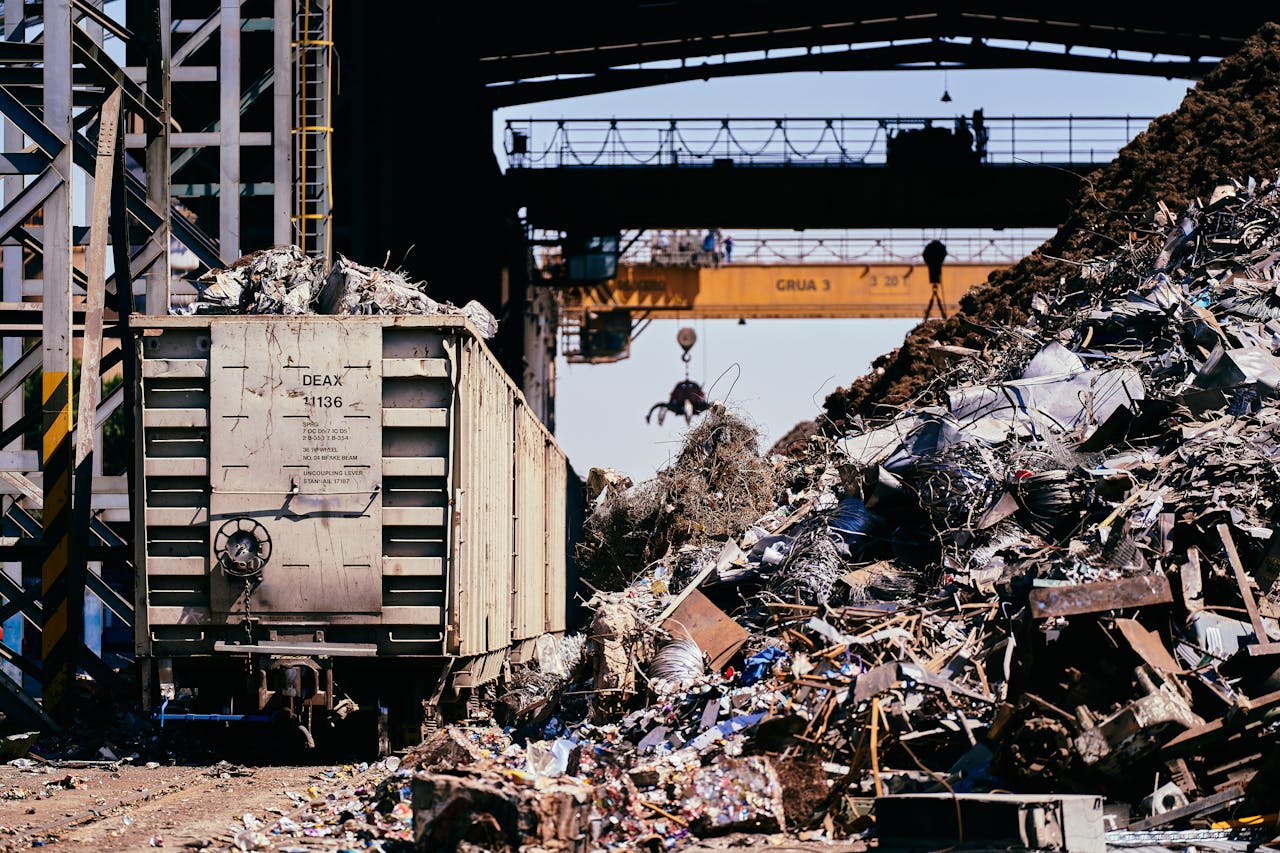 core-values A dynamic industrial scene featuring a scrap yard with a train car and crane lifting debris.