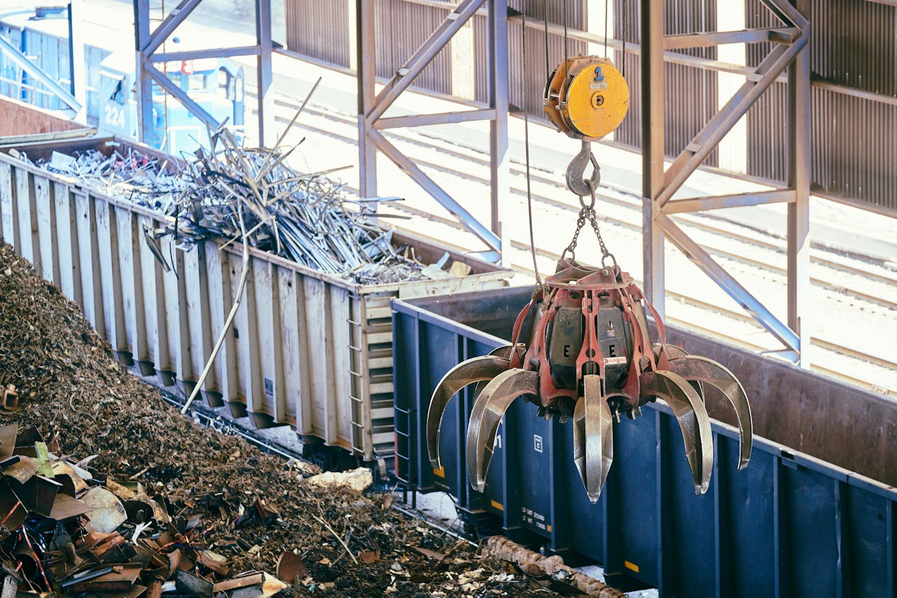 about-img Overhead crane sorting scrap metal in an industrial recycling facility.